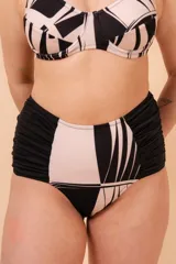 Bombacha de bikini tiro alto con laterales drapeados y refuerzo interno en tela de faja. Diseño estampado abstracto en blanco y negro.