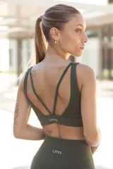 Top deportivo negro con breteles finos cruzados en la espalda y logo de la marca en el lateral izquierdo.