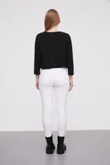 Pantalón en color negro, de corte skinny y ajuste ceñido al cuerpo.