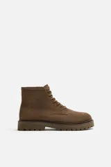 Bota acordonada color marrón de cuero serraje, con puntera redondeada y suela track.