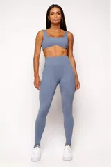 Top deportivo gris con escote cuadrado, breteles anchos y calce ajustado. Incluye forro interno y apertura para almohadilla removible.