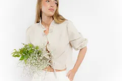 Blusa color blanco de lino, con mangas 3/4 y volados en el frente. Se ata con lazos en el centro.