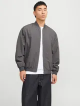 Campera bomber gris de poliéster, con cuello baseball, cierre frontal con cremallera, bolsillos delanteros y puños de canalé.