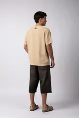 Remera color crudo de lino con textura entramada, calce cómodo y mangas cortas.