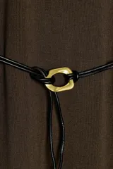 Vestido negro de tejido de punto, corte midi y silueta holgada, con cuello alto acanalado y mangas cortas tipo murciélago. Se ajusta a la cintura con un cinturón fino de efecto piel negro con hebilla dorada en forma de C.