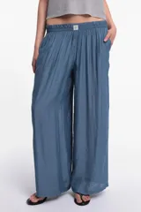 Pantalón de tela color celeste con textura arrugada, corte amplio y cintura elastizada.