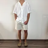 Camisa negra tejida con cuello solapa, manga corta y corte oversize.