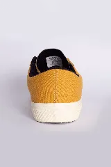 Zapatillas bajas color beige claro, con cordones y suela blanca.