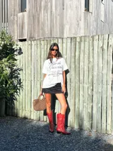 Botas de caña alta estilo cowboy, color rojo brillante, con bordados decorativos en hilo blanco contrastante. Presentan punta afilada y tacón bajo y angular.