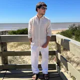 Camisa de manga larga color blanco, con textura de lino arrugado, cuello camisero y botones frontales.