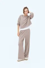 Pantalón de corte relajado color gris topo, confeccionado en felpa liviana de mezcla de algodón. Cuenta con cintura elástica fruncida, bolsillos laterales discretos y piernas rectas.