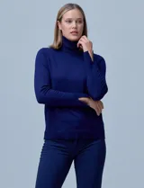 Polera de punto fino marca Nienty, color blanco, con cuello alto volcado y mangas largas con detalle de tajo en los puños.