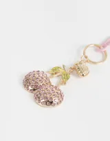 Llavero con dije de cerezas cubiertas de strass rosa, con dije de frutilla dorada y mosquetón rosa.