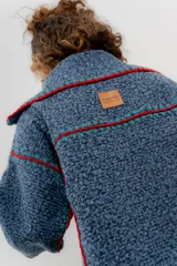 Chaqueta azul con detalles de crochet rojo y verde, de paño de lana, corte oversized.