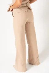 Pantalón de vestir color beige, de corte palazzo y tiro alto.