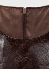 Minivestido negro de cuero sintético con cuello redondo y corte recto.