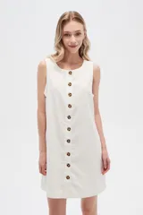 Vestido blanco de lino, corte entallado, con botones frontales, cuello a la base y breteles anchos.