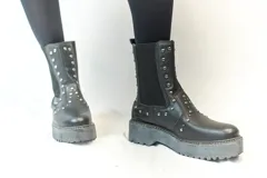 Bota Chelsea color crema con plataforma track negra y elásticos laterales con tachas plateadas.