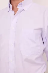 Camisa celeste con rayas verticales blancas, de corte clásico, con cuello abotonado, manga larga y bolsillo en el pecho.