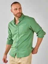 Camisa de lino verde con cuello abotonado, manga larga con puños abotonados y bolsillo en el pecho.