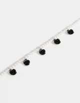 Collar corto de perlas blancas con dijes de rosas rojas.