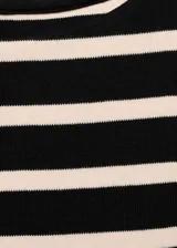 Vestido corto con cuerpo ajustado a rayas horizontales en blanco y negro, falda corta color piel con frunce en la cintura.