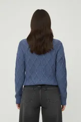 Sweater de chenille color blanco, con punto trenzado, diseño holgado y cuello a la base.