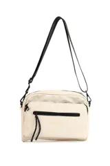 Bandolera color crema con correa larga negra ajustable, bolsillo frontal con cierre y logo estampado.