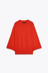 Sweater de punto color naranja con cuello redondo y mangas anchas hasta el codo.