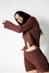 Buzo de lurex color chocolate, con cuello en V y abertura en el centro.