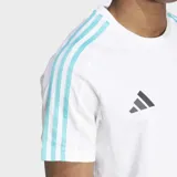Remera blanca de algodón con cuello redondo y mangas cortas. Presenta tres tiras celestes en los hombros, logo de Adidas y logo de Mercedes AMG Petronas en el pecho.