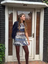 Collar con cordón fino color ocre, dije de nácar blanco con forma irregular y aplique metálico dorado.