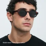 Gafas de sol unisex con montura carey geométrica, lentes polarizadas negras con protección UV400, varillas sobresalientes y diseño retro-chic.