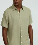 Camisa masculina de manga corta, cuello inglés y abotonado delantero, confeccionada en algodón con textura. Presenta un calce comfort más holgado.