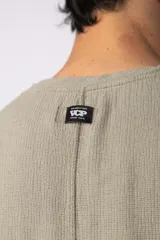 Musculosa oversize color crudo, tejida en lino con textura marcada y terminaciones deshilachadas.