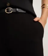 Pantalón de vestir negro de sastrería, corte wide leg y tiro alto. Presenta cierre frontal y trabillas en la cintura, e incluye un cinturón fino de poliuretano.