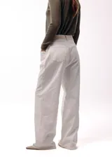 Jean wide leg color natural, de tiro medio con bolsillos delanteros amplios y silueta fluida.