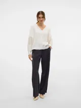 Camisa blanca de mangas largas abullonadas con detalle de bordado en las mangas y escote en V.
