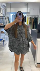 Camisa oversize con estampado animal print en tonos blanco y negro, con cuello clásico y cierre frontal con botones.