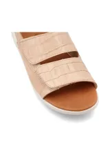 Sandalia color beige con capellada de cuero, suela blanca y ajuste con hebilla.