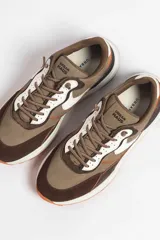 Zapatillas deportivas color beige con detalles en marrón y amarillo.