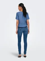 Camisa de denim celeste con lazo. Diseño de cuello camisero, mangas cortas tipo box y calce regular. Incluye detalle de lazo y recorte en la cintura.