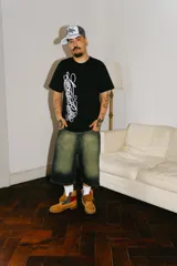 Bermuda baggy de jean con lavado verde, bordado en negro y rojo, cierre y botón personalizado, corte amplio y bolsillos grandes.