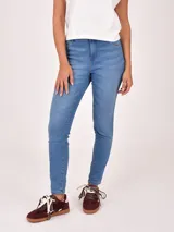 Jean de mujer, tiro medio-alto, color azul claro con lavado uniforme. Corte ajustado tipo skinny o slim fit.