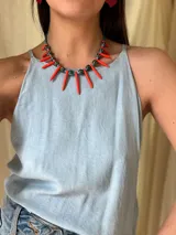 Collar corto con cuentas de cerámica, pinchos de piedra reconstituida color naranja, cristales checos y mostacillas. Se cierra con cadena de acero quirúrgico para regular el largo.