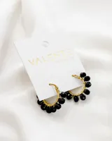 Aros de acero dorados con cuentas de vidrio facetado color negro.