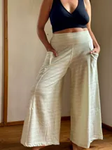 Pantalón palazzo de tiro alto con estampado de rayas horizontales color crema y celeste. Confeccionado en rústico de algodón, con bolsillos laterales, elástico en la espalda y faja ancha en la cintura.