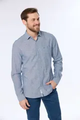 Camisa de lino color beige, de manga larga, con cuello clásico y bolsillo en el pecho.