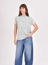 Remera blanca con estampado abstracto en color marrón.