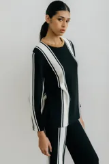 Sweater de punto color blanco con rayas verticales negras y cuello redondo color beige.